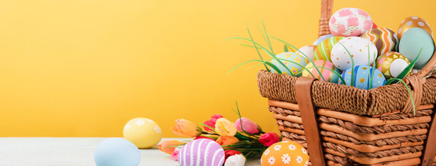 En gul bakgrund och en korg full av påskägg
