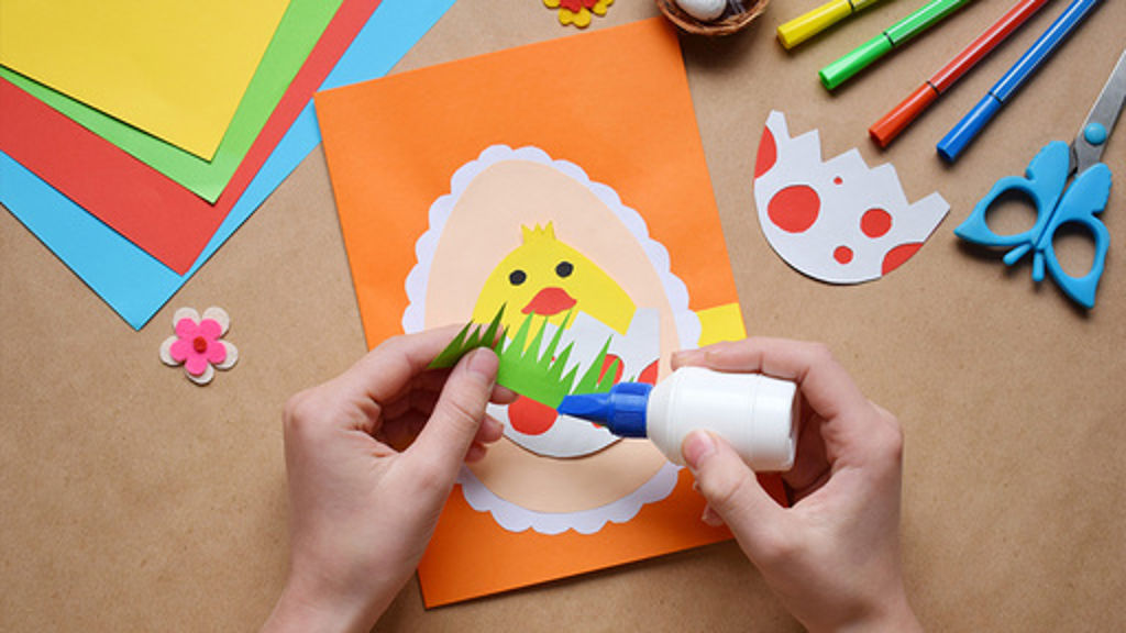 Någon som sitter vid ett bord och gör påskpyssel