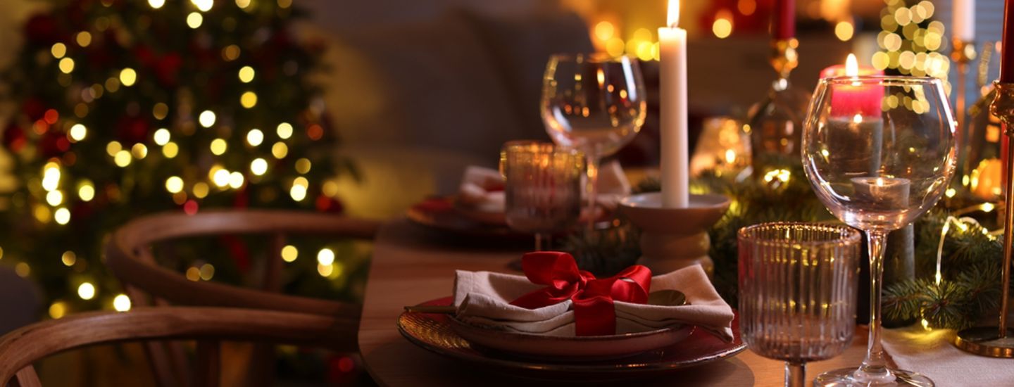 Ett dukat julbord i ett vardasgrum med en julgran i bakgrunden