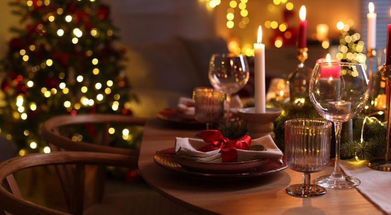 Ett dukat julbord i ett vardasgrum med en julgran i bakgrunden
