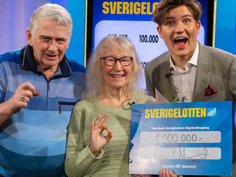 Två vinnare med Sverigelotten-check tillsammans med programledare. 