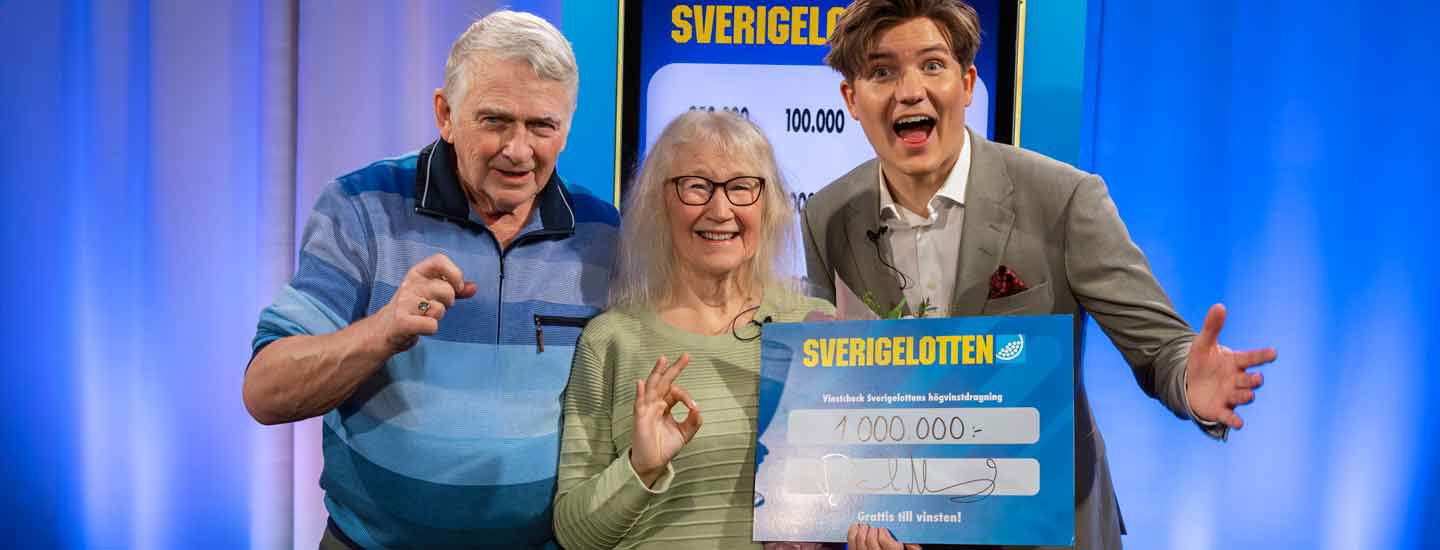 Två vinnare med Sverigelotten-check tillsammans med programledare.