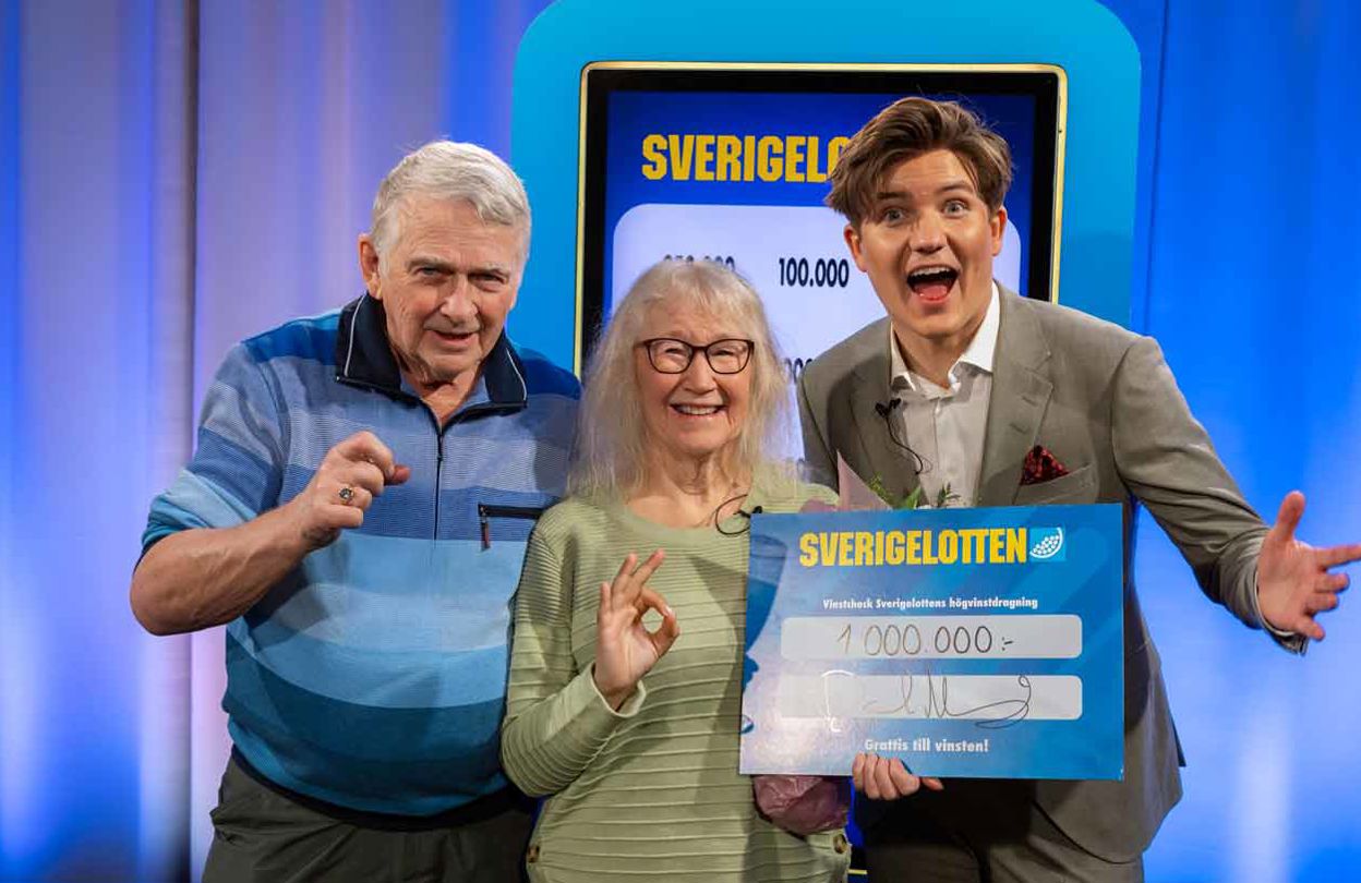 Två vinnare med Sverigelotten-check tillsammans med programledare.