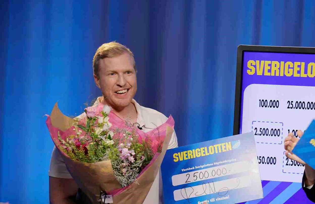 Vinnare med Sverigelotten-check och blommor tillsammans med programledare i studio.