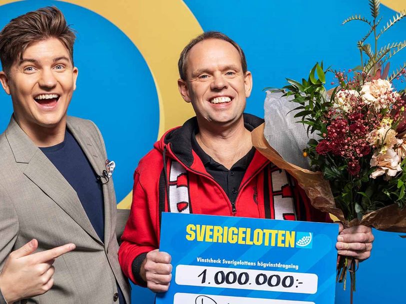 Vinnare med Sverigelotten-check och blommor tillsammans med programledare i studio.