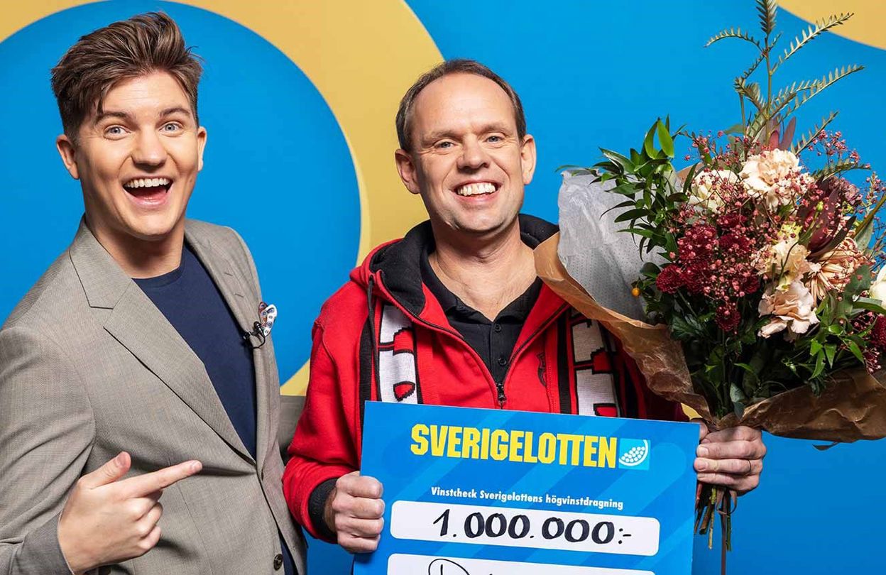 Vinnare med Sverigelotten-check och blommor tillsammans med programledare i studio.