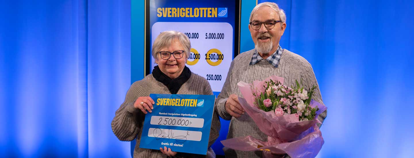 Två vinnare med Sverigelotten-check och blommor.