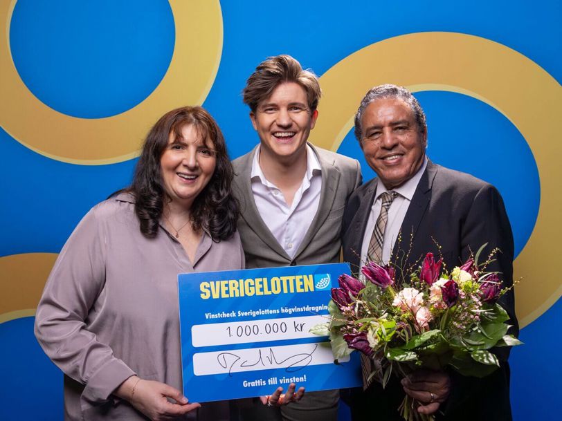 Tre glada personer som skrattar där en av dem vunnit 1 000 000 kr på Sverigelotten